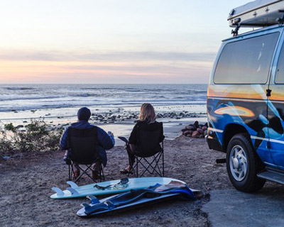 surfers sitting in camping chairs looking at surf