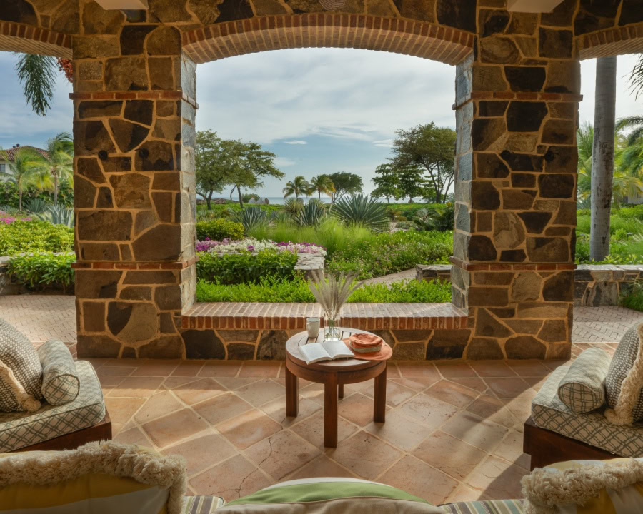 outdoor seating area overlooking lush garden and ocean view