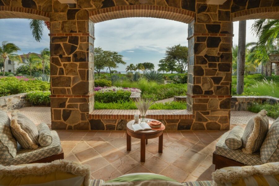 stone terrace with seating area, overlooking lush garden and ocean view