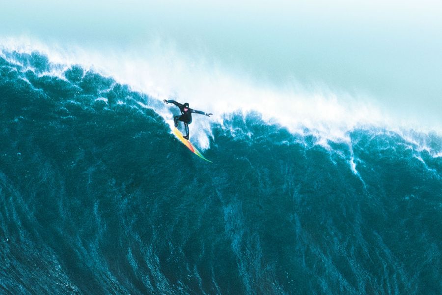 surfer riding mavericks surf break