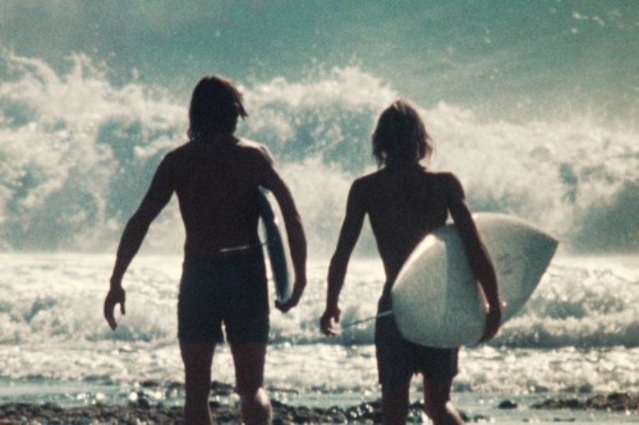 two surfers with surfboards on a beach