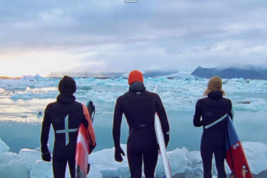 three surfers with surfboards
