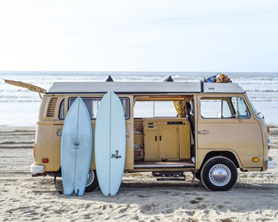 california campervan rentals vintage yellow vw with surfboards on it