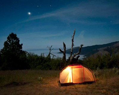 glowing tent under moonlight sky