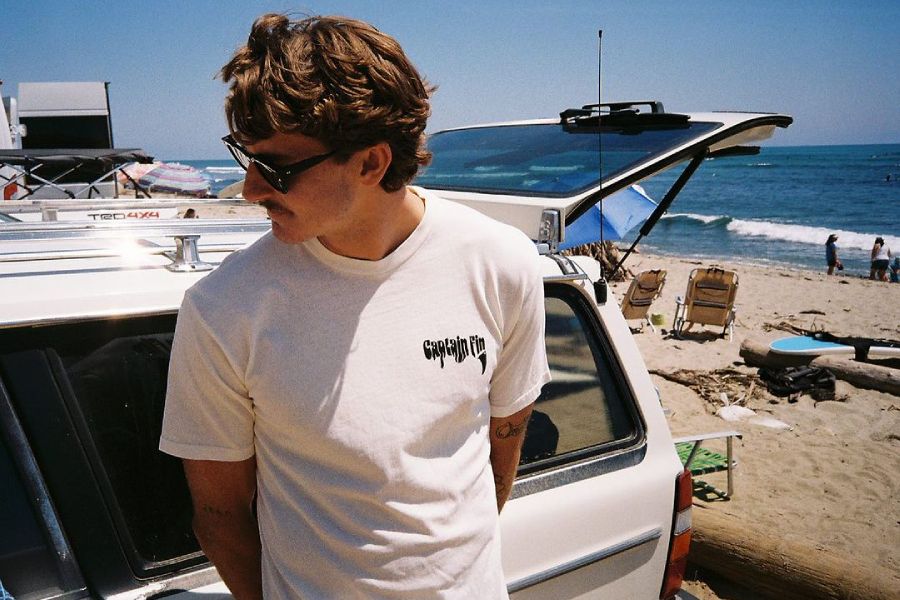 man at the beach wearing captain fin co surf brand clothing