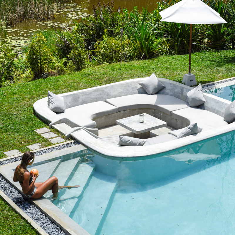 woman lounging on steps of pool