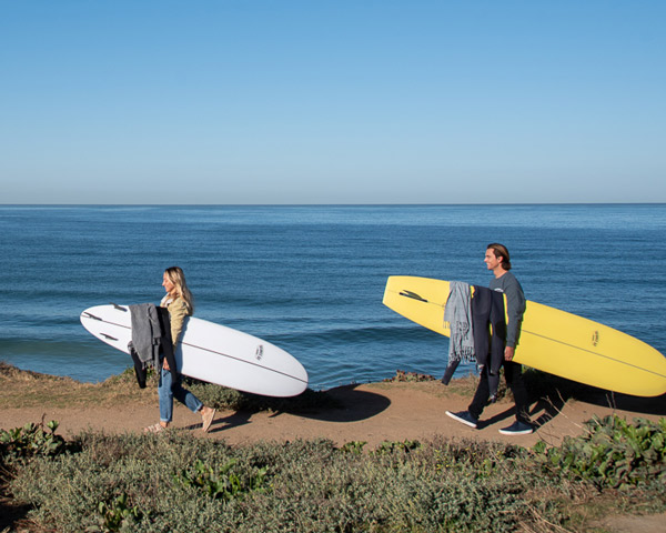 surfers walking on bluff
