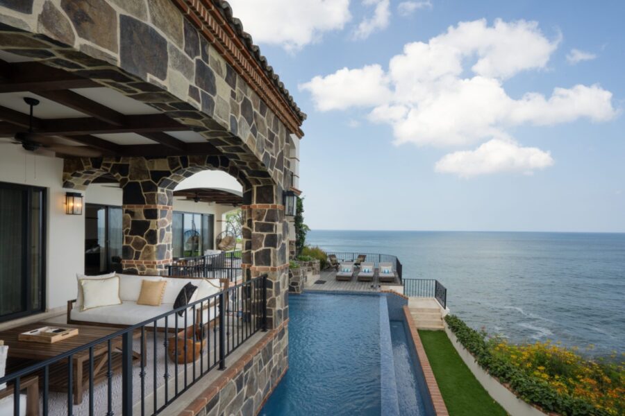 A luxurious stone balcony with an infinity pool overlooking the ocean