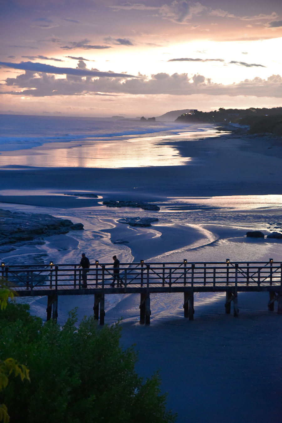 Twilight view of boardwalk over serene beach