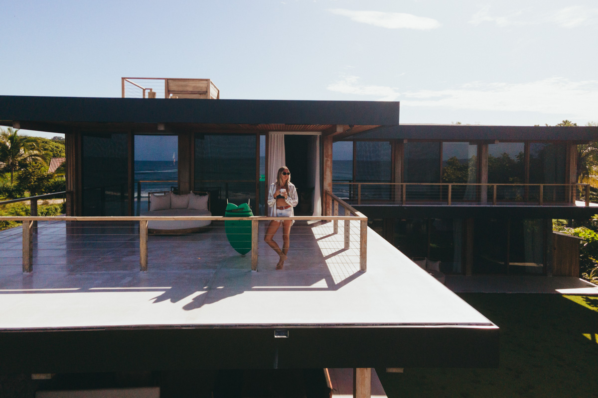 woman with coffee on villa balcony