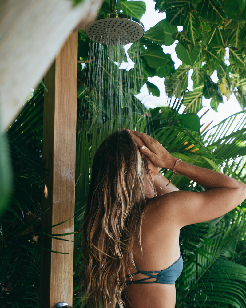 woman rinsing in tropical outdoor shower