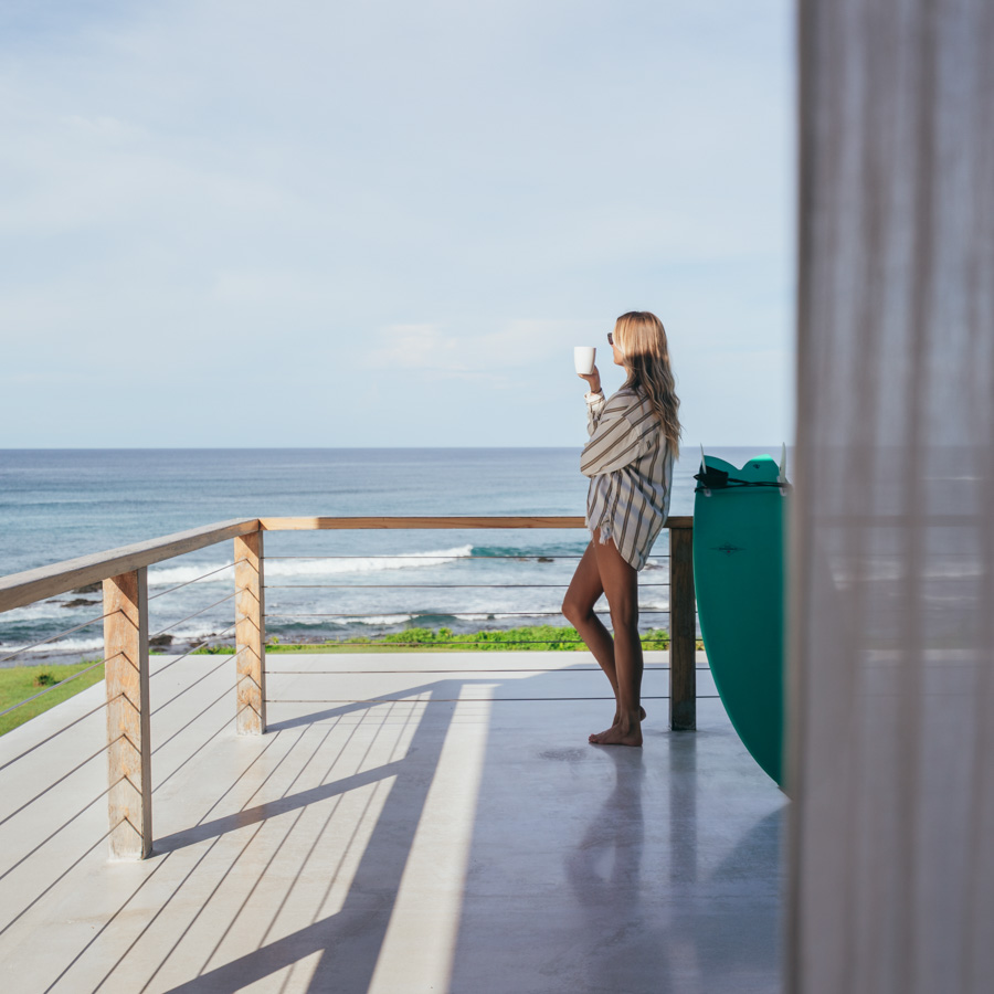 woman drinking cafe on oceanview balcony