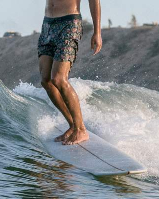 man longboarding wearing boardshorts by Vissla surf brand