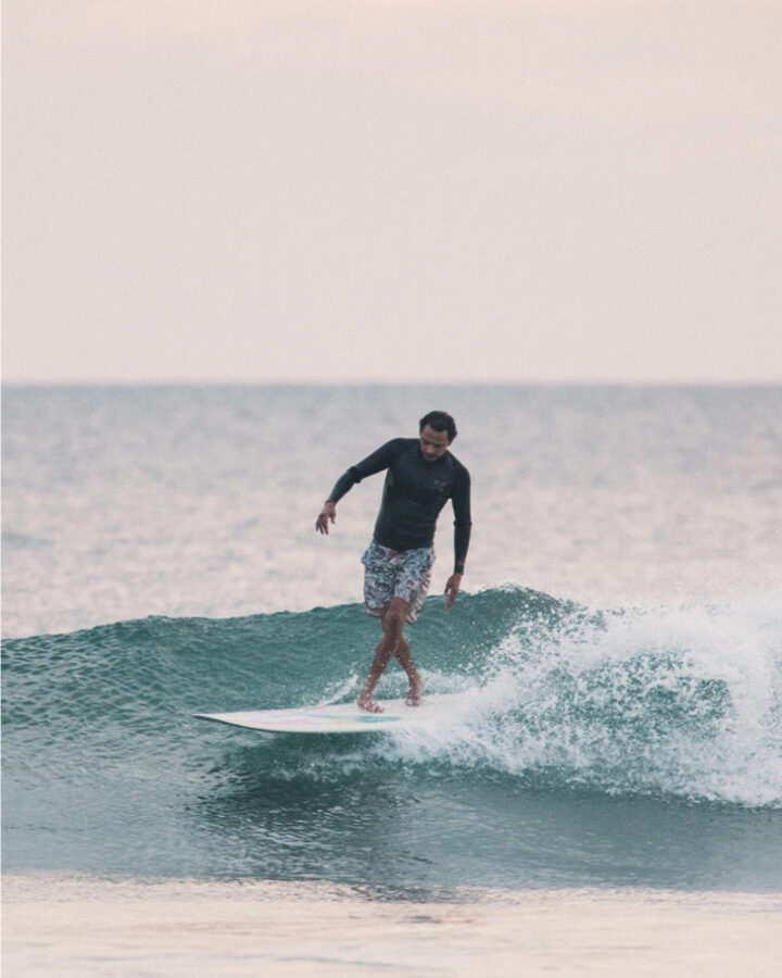 man surfing wave and wearing boardshorts by surf brand howler brothers