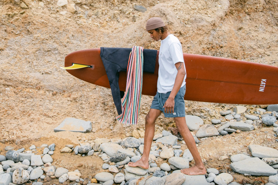 surfer walking with longboard surfboard