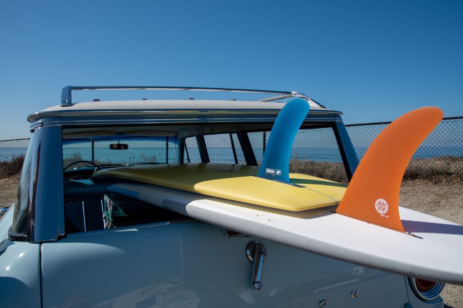 single fin boards in car under blue sky