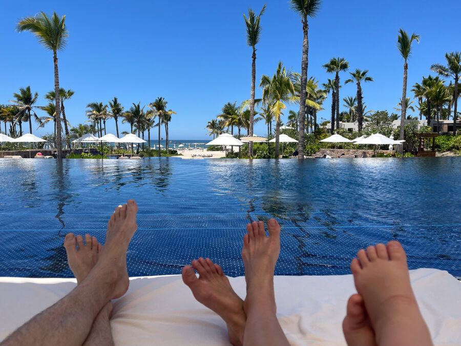 Susurros del Corazon Review / parents' and child's feet by the pool at luxury resort in Punta de Mita, Mexico