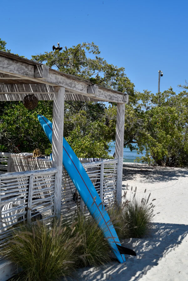 Susurros del Corazon Review / surfboard on a sandy beach at luxury resort in Punta de Mita, Mexico