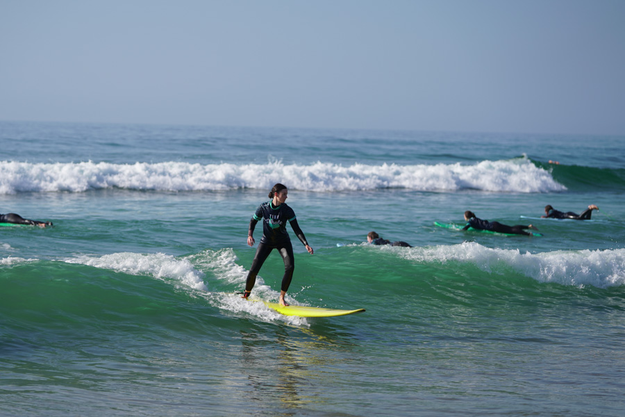 Woman learning how to surf with Tiny Whale Surf Camp in Portugal.