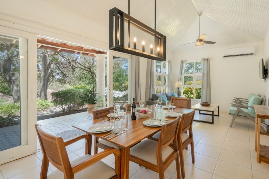 elegant dining area with a wooden table offering a serene view of the garden outside